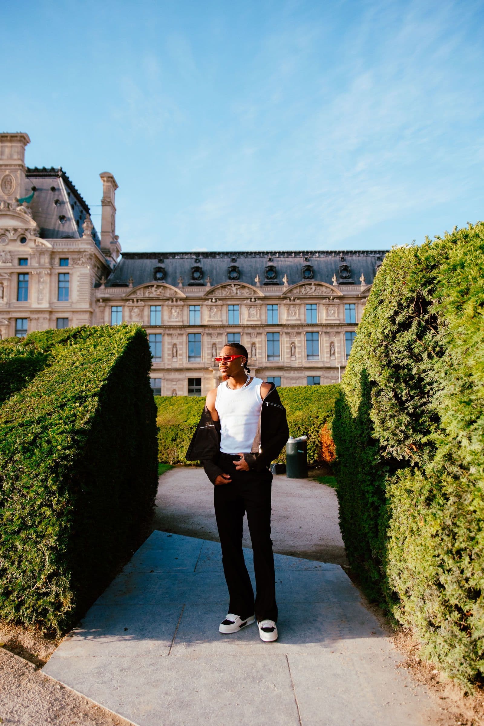 Justin Jefferson stands in a garden path with a large historic building in the background