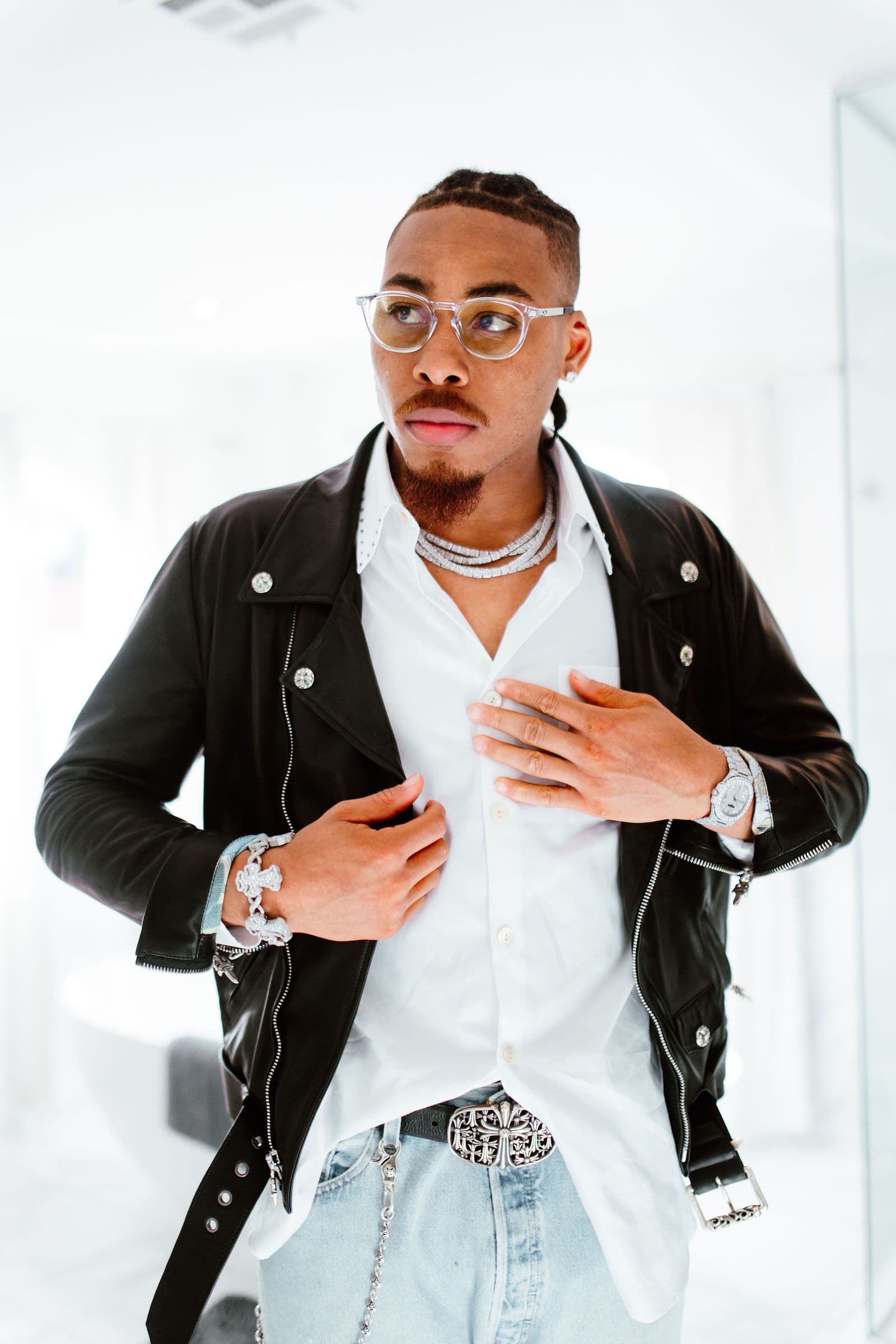 Justin Jefferson poses in a black leather jacket, white shirt, and glasses