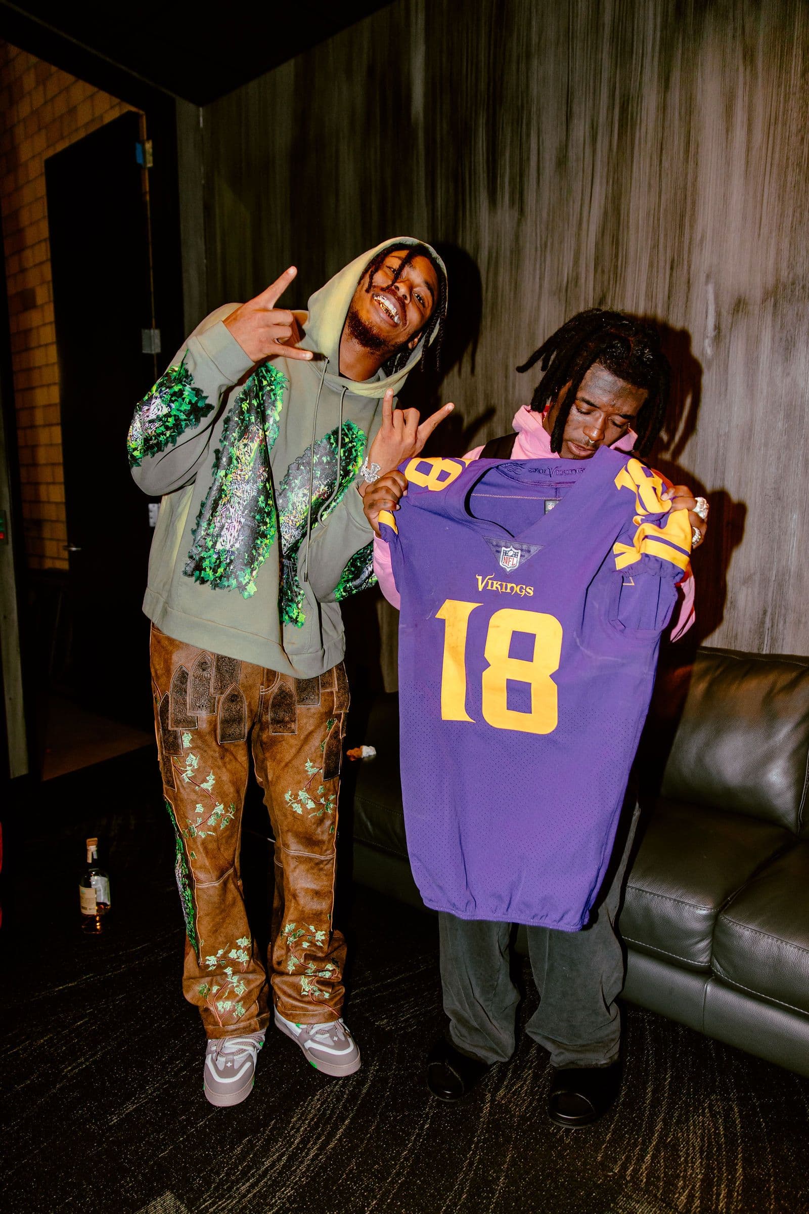 Justin Jefferson and another man pose with a Vikings jersey indoors