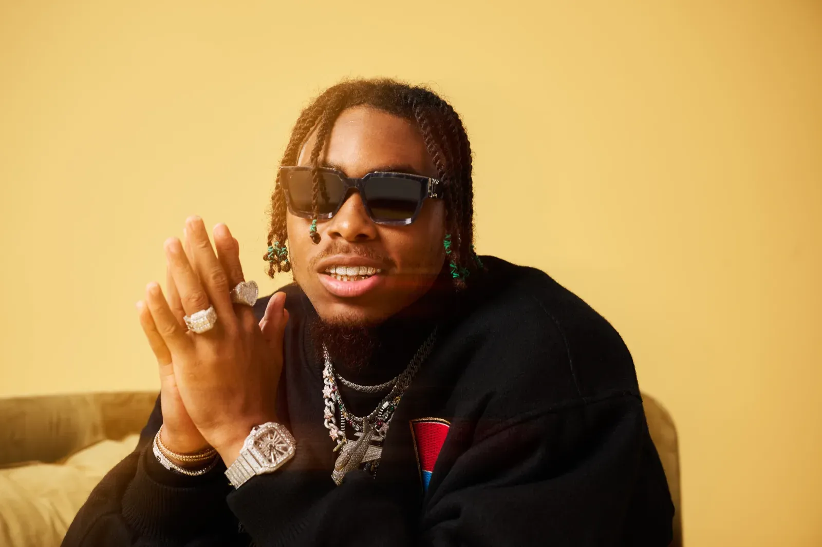 Justin Jefferson leaning forward in shades and diamond rings, editorial studio shoot
