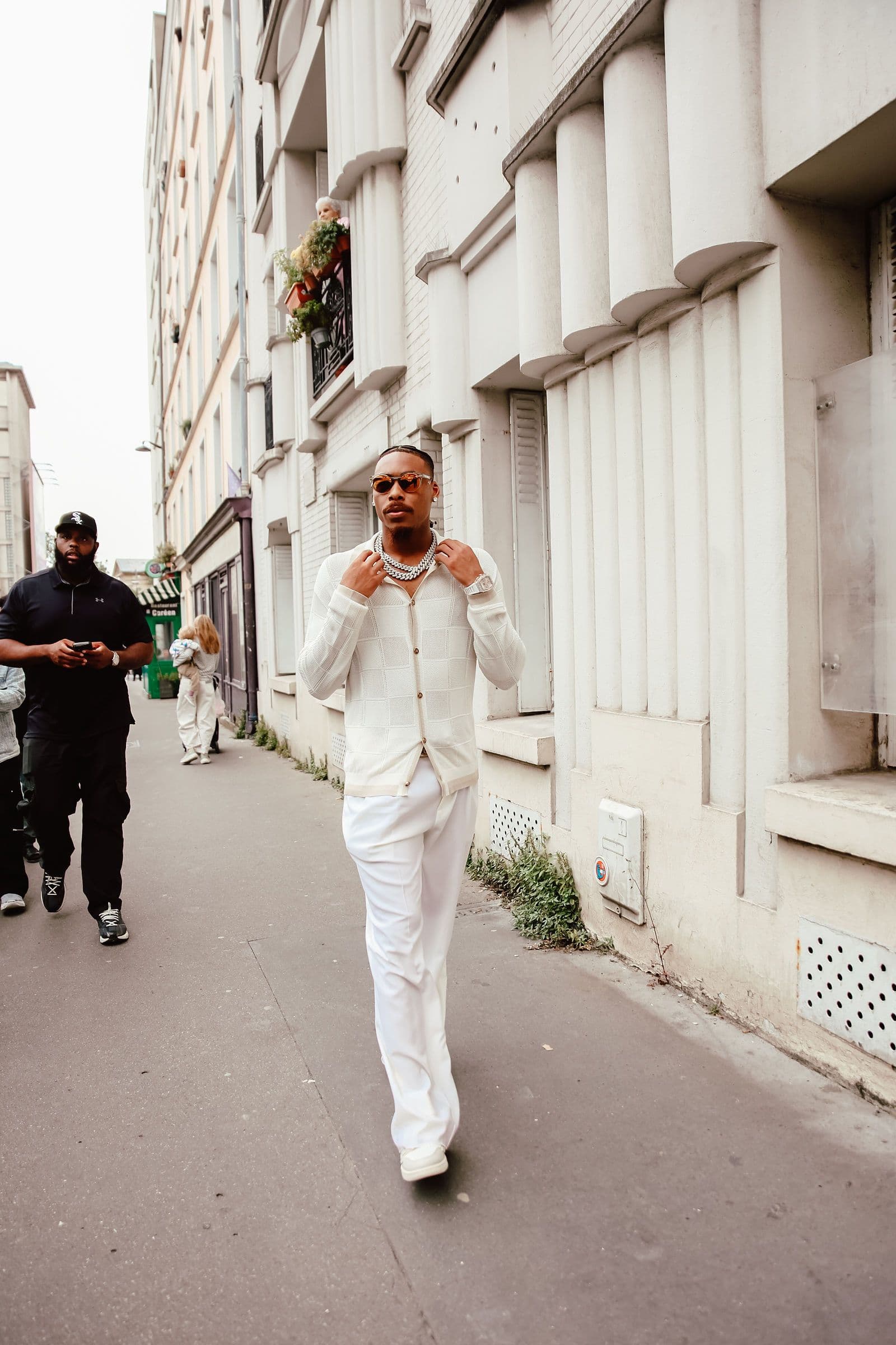 Justin Jefferson walks down a street in a white outfit with other people