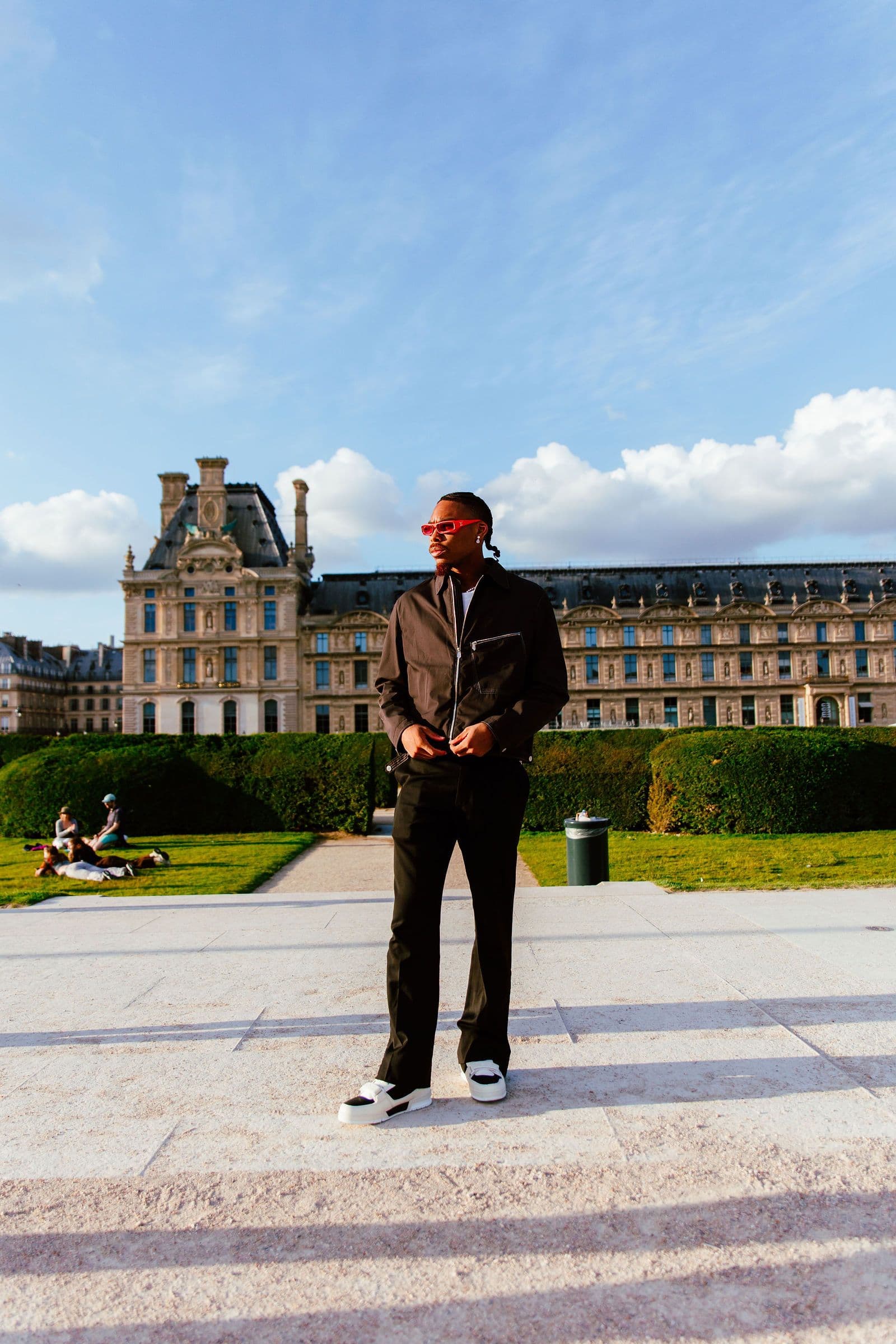 Justin Jefferson stands outdoors in a park with a large building in the background