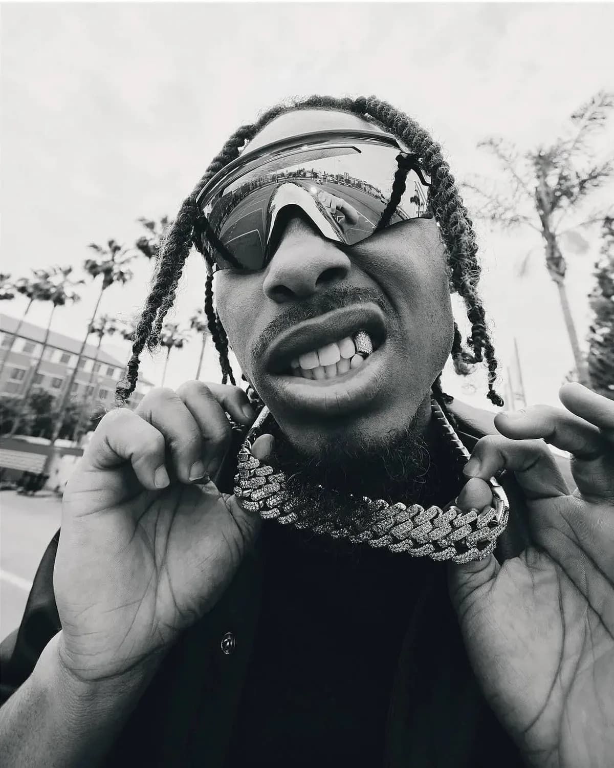 Black-and-white portrait of Justin Jefferson in wraparound shades holding his chain
