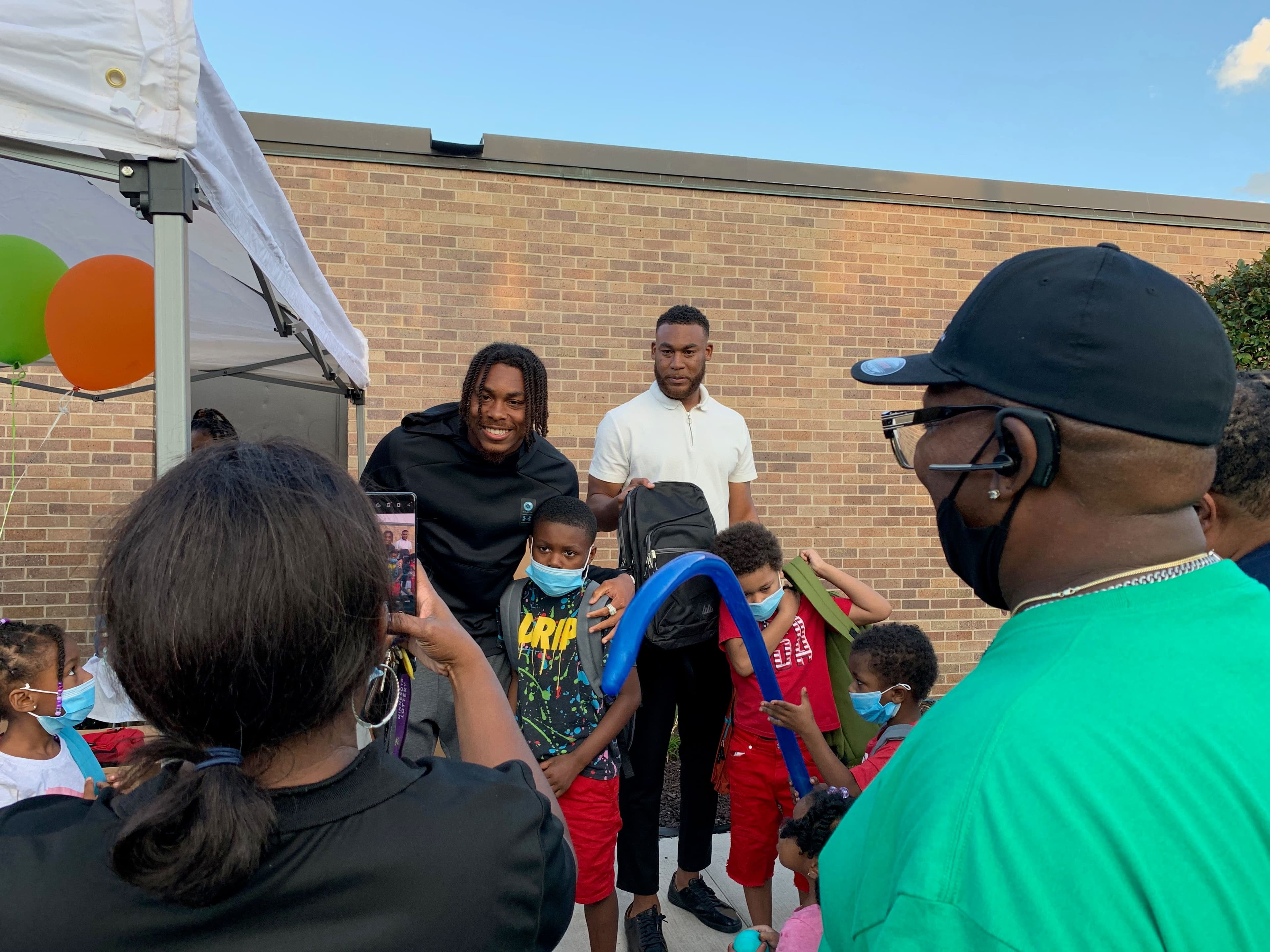 Justin Jefferson and a teammate with kids at the Backpack Drive